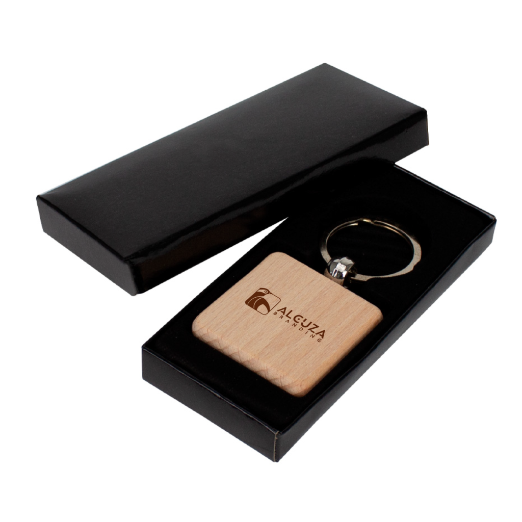 Llavero de madera personalizado con logo de Alcuzabranding en caja de presentación negra